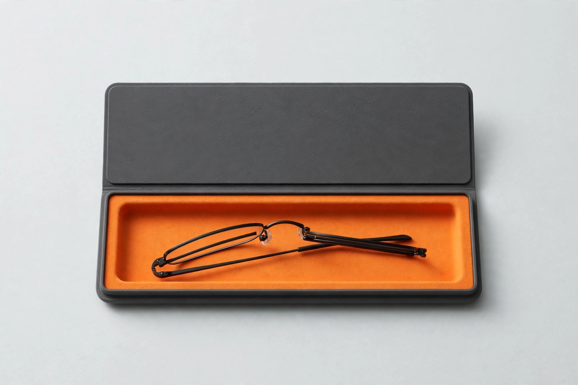 Slim charcoal EVA flat case with orange lining holding folded reading glasses