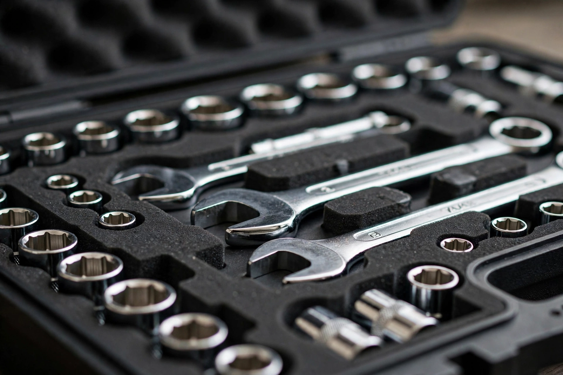 Macro of precision die-cut foam compartments holding chrome wrenches with crisp edges